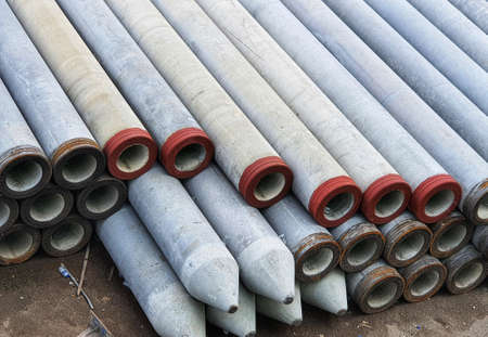 Pile of precast concrete spun pile in a construction project stockyard.の写真素材