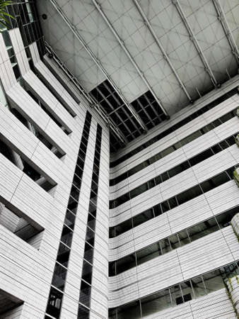 The inside of a tall building, lots of glass and very futuristic.の写真素材