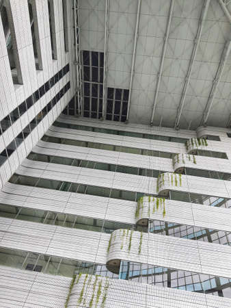 The inside of a tall building, lots of glass and very futuristic.の写真素材