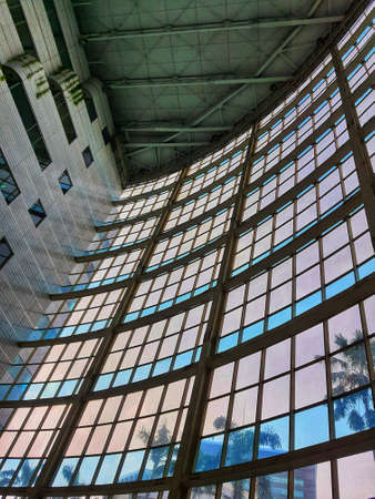 The inside of a tall building, lots of glass and very futuristic.の写真素材