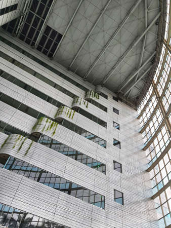 The inside of a tall building, lots of glass and very futuristic.の写真素材