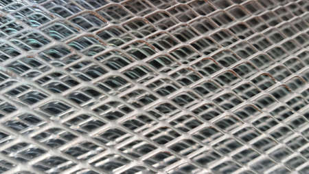 Close up photo of steel wire material, wire mesh. Which has a checkerboard pattern or forms a grid.の写真素材