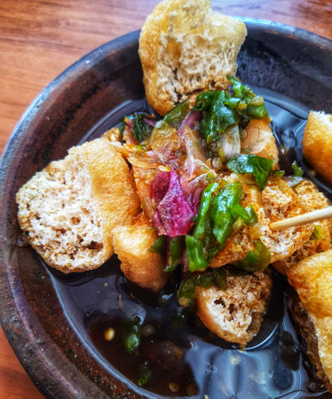 Tahu gejrot is a typical food of West Java with the main ingredient is fried tofu. This food consists of fried tofu which is cut into pieces and then added with a sauce with chili, garlic, shallots, sugar. It is usually served on a small clay plate.の写真素材