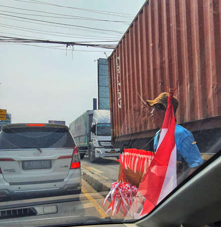Jakarta in August 2022. A hawker is selling red and white flags in August.の写真素材