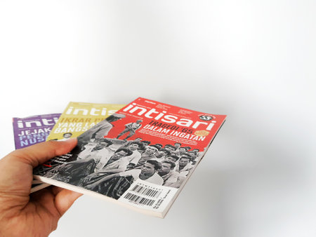 West Java, August 2022. A hand is holding some Intisari magazines. Intisari is the name of a monthly magazine that originated in Indonesia and was first published in 1963 in the Indonesian language.のeditorial素材