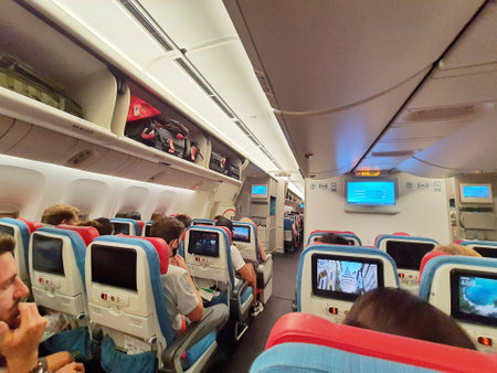 Turkey in July 2022. Situation from the cabin of a Turkish Airlines economy class plane where the seat consists of three parts, right, left and center. Each section consists of three seats and all seats are equipped with a touch screen for in-flight entertainment.の写真素材