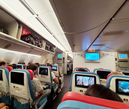 Turkey in July 2022. Situation from the cabin of a Turkish Airlines economy class plane where the seat consists of three parts, right, left and center. Each section consists of three seats and all seats are equipped with a touch screen for in-flight entertainment.の写真素材