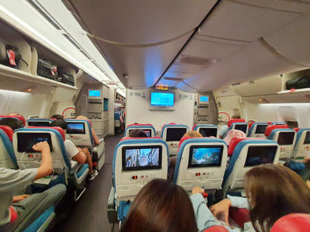 Turkey in July 2022. Situation from the cabin of a Turkish Airlines economy class plane where the seat consists of three parts, right, left and center. Each section consists of three seats and all seats are equipped with a touch screen for in-flight entertainment.の写真素材