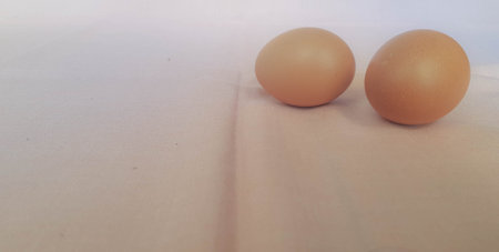 This is a photo of three eggs next to each other on a pink background.の写真素材