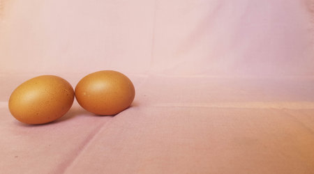 This is a photo of three eggs next to each other on a pink background.の写真素材