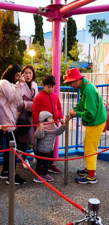 Osaka, Japan in April 2019. Children and several adults are queuing to enter a ride at Universal Studios Japan. An officer checked their admission ticket.のeditorial素材