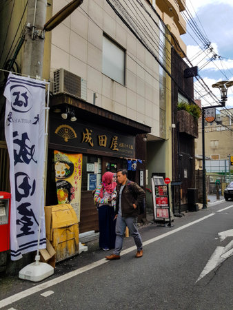 Osaka, Japan on April 10, 2019. A Muslim young man and Muslim woman will enter a halal ramen shop in Osaka. Halal ramen can be eaten by Muslims safely because it does not contain haram ingredients.のeditorial素材