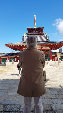 Tokyo, Japan on April 15, 2019. An old man prays at a temple in Japan. This red shrine is located in the Tennoji area, Osaka. Very quiet and comfortable to pray and worship.のeditorial素材