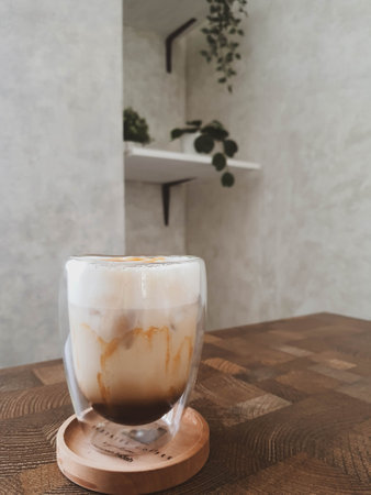 Glass of Ice Salted Caramel Macchiato. Coffee with a mixture of milk and caramel syrup which is very fresh, sweet, slightly bitter and salty is very delicious enjoyed on a hot day.の写真素材