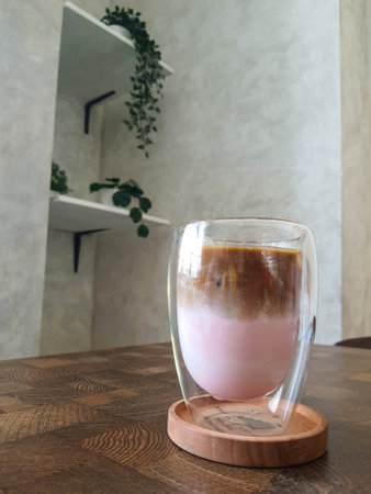 A Glass of Strawberry Latte Ice. Coffee with a mixture of milk and strawberry syrup that is very fresh, sweet and slightly bitter is very delicious to be enjoyed on a hot day. Suitable for those of you who like the taste of strawberries who want to drink coffee.の写真素材