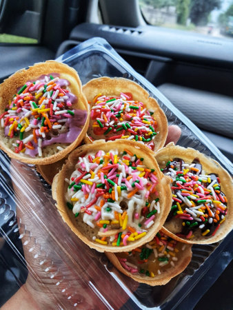 Martabak Mini, is a typical Indonesian pancake. Street food made from flour, yeast, eggs and sugar baked and topped with butter and chocolate sprinkles.の写真素材