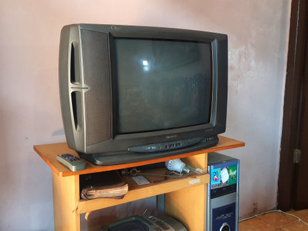 Central Java, Indonesia on July 9, 2022. Ancient items on a computer desk. A sharp tube television, an ancient computer CPU, and a polytron radio and tape player.のeditorial素材