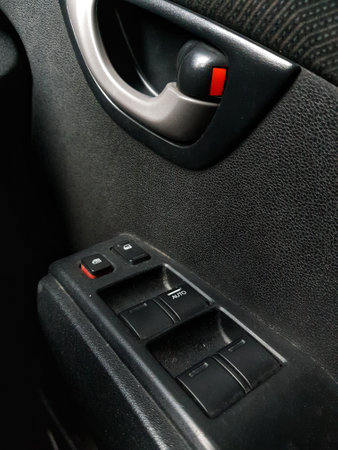 Components of a car, which is on the right side of the car door, namely the handle or car door opener and several buttons below it to lock the car and open the car window.の写真素材