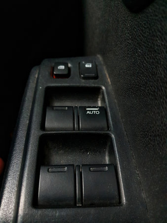 Components of a car, which is on the right side of the car door, namely the handle or car door opener and several buttons below it to lock the car and open the car window.の写真素材