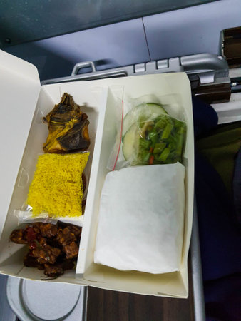 A set of nasi rames sold on long-distance trains of PT. Indonesian Railways. Consisting of rice, chicken, serundeng, and vegetables and chili sauce.の写真素材