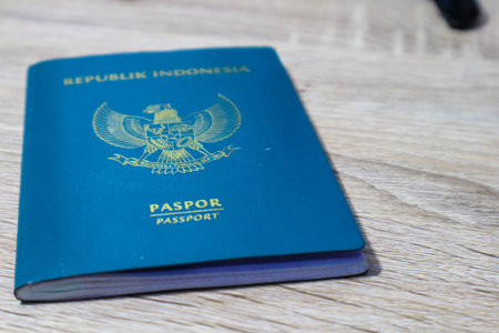 Indonesian green passport on a wooden table. This passport is an identity for Indonesian citizens...