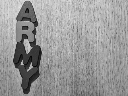 Black and white photo of the alphabet on a wooden table that says ARMY. Army is a fandom of the popular KPOP group BTS which stands for Adorable Representative M.C For Youth.のeditorial素材