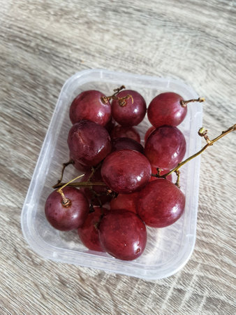 Complementary food supplies for meal box children, in the form of fruit. A small plastic box containing grapes fruit. Contains lots of vitamins and antioxidants.の写真素材