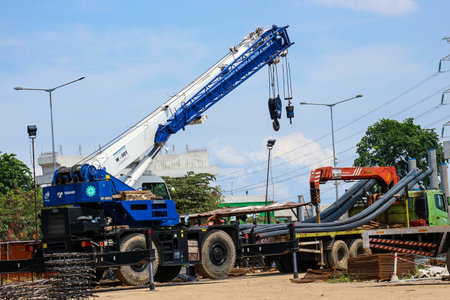 Jakarta, Indonesia in October 2022. A mobile crane is carrying out the lifting of iron material, carried out in a workshop on cutting and forming structural steel.の写真素材