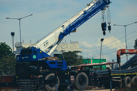 Jakarta, Indonesia in October 2022. A mobile crane is carrying out the lifting of iron material, carried out in a workshop on cutting and forming structural steel.の写真素材