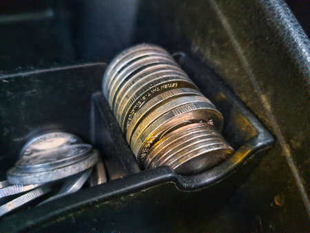 Some rupiah coins and one hundred thousand rupiah notes and some other money in a box provided on the dashboard of the car which functions as a place for coins.の写真素材