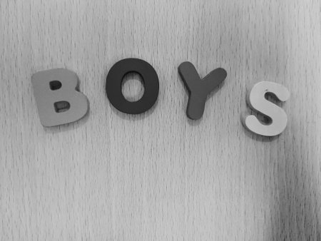 The arrangement of colorful letters that read BOYS is placed on a background with a wood pattern.の写真素材