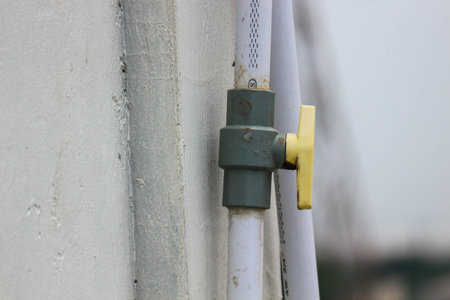 Valves or taps attached to pipes to open and close flow. This valve is yellow with white tubing.の写真素材
