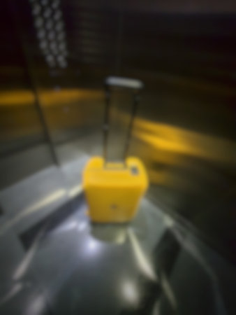 Defocused blurred photo of a yellow suitcase in an apartment hallway.の写真素材