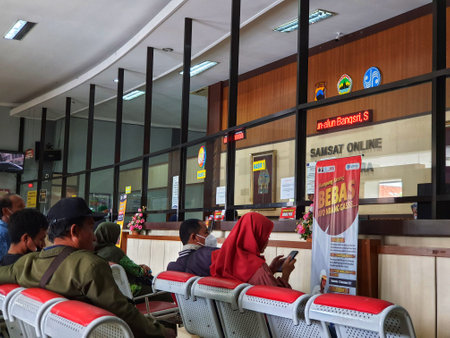 Jepara, Indonesia in November 2022. People are sitting waiting in line at the Jepara Branch Samsat Office. SAMSAT or One-stop Administration Services Office.のeditorial素材