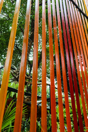 Decoration of a garden, a vertical fence with reddish-orange colors arranged in such a way as to show the effect of color gradations.の写真素材