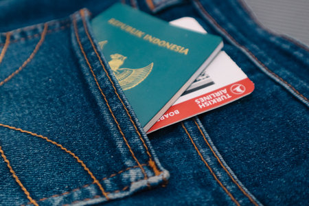 Indonesia in July 2022. An Indonesian passport and a Turkish Airlines boarding pass in a jeans pocket. This photo is suitable as an illustration of traveling abroad.のeditorial素材