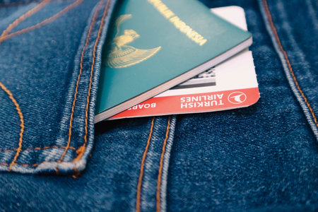 Indonesia in July 2022. An Indonesian passport and a Turkish Airlines boarding pass in a jeans pocket. This photo is suitable as an illustration of traveling abroad.のeditorial素材