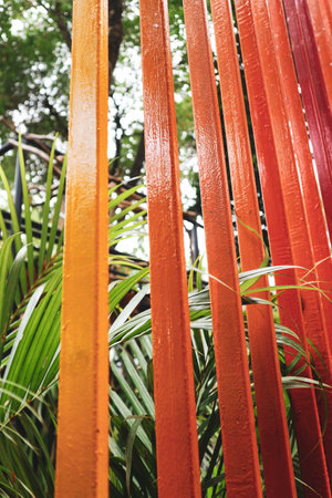 Decoration of a garden, a vertical fence with reddish-orange colors arranged in such a way as to show the effect of color gradations.の写真素材