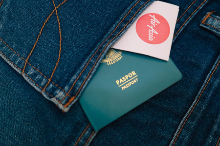 Indonesia in July 2022. An Indonesian citizenship passport and an Air Asia Airlines boarding pass in a jeans pocket. This photo is suitable as an illustration of traveling abroad.のeditorial素材