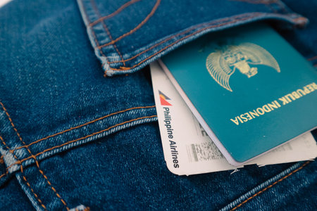 Indonesia in July 2022. An Indonesian passport and a Philippines Airlines boarding pass in a jeans pocket. This photo is suitable as an illustration of traveling abroad.のeditorial素材