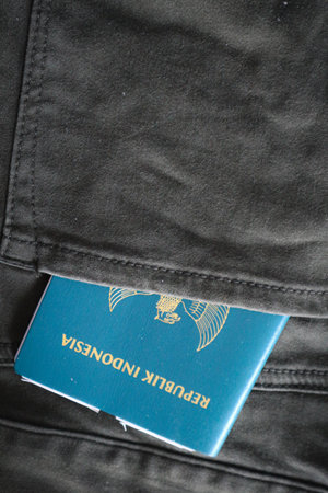 An Indonesian citizenship passport in a green denim pocket. This photo is suitable as an illustration of traveling abroad.の写真素材