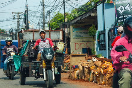 Jakarta, Indonesia in November 2022. Front view of a motorcyclist driving on a busy street on the outskirts of Jakarta.のeditorial素材