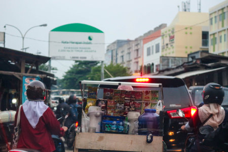 Jakarta, Indonesia in November 2022. Back view of a motorcyclist driving on a busy street on the outskirts of Jakarta.のeditorial素材
