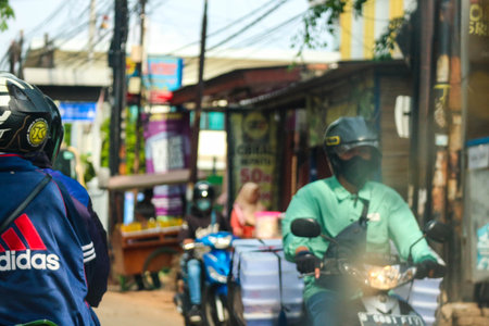 Jakarta, Indonesia in November 2022. Front view of a motorcyclist driving on a busy street on the outskirts of Jakarta.のeditorial素材
