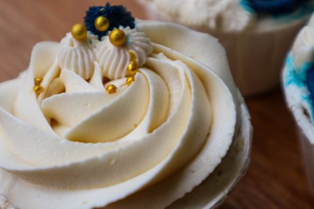 Luxurious and elegant cupcakes, with white cream and navy blue with gold sprinkles. It has a sweet and creamy taste.の写真素材