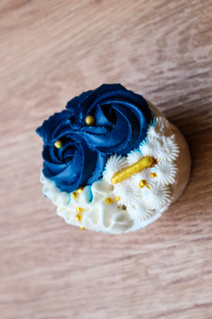 Luxurious and elegant cupcakes, with white cream and navy blue with gold sprinkles. It has a sweet and creamy taste.の写真素材