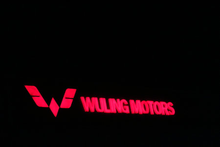 Bekasi, Indonesia in July 2022. The WULING MOTORS logo shining brightly at night against the dark night sky. Wuling Motors is a vehicle brand from Liuzhou, Guangxi, China. This brand is run by the company Liuzhou Wuling Automobile Industry Co., Ltd.,のeditorial素材