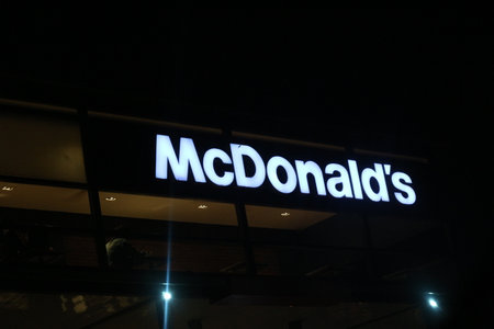 West Java, Indonesia on July 2022. Glowing McDonalds restaurant sign against night sky. Logo of Mcd Drive Thru. McDonald's is the world's largest restaurant chain by revenue,のeditorial素材