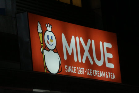 Bekasi, Indonesia on July 2022. Glowing MIXUE restaurant sign against night sky. Mixue is a popular cold beverage ice cream shop. It is originally from China and recently opens in Indonesia.のeditorial素材