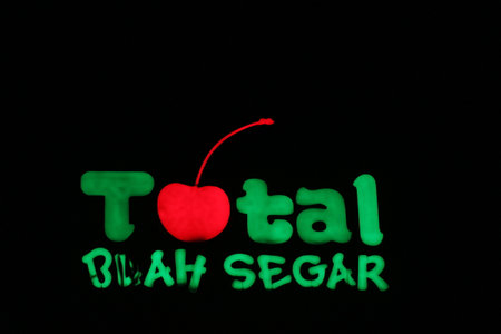 Bekasi, Indonesia in July 2022. The TOTAL Buah Segar logo shining brightly at night against the dark night sky. Total fresh fruit is a big fruit shop that is famous in Indonesia because it provides many types of fruit.のeditorial素材